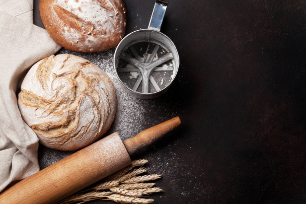 Various crusty bread and buns on blackboard background. Top view with space for your text - 写真・画像