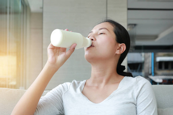Close up Young woman drinking some milk from a bottle. - Foto, Imagen