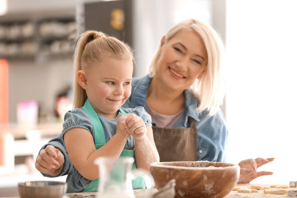 Little girl and grandmother with flour  - Foto, Imagen