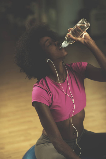 young afro american woman in gym on pilates workout break teaking breath and fresh drinking  water - Foto, Imagem
