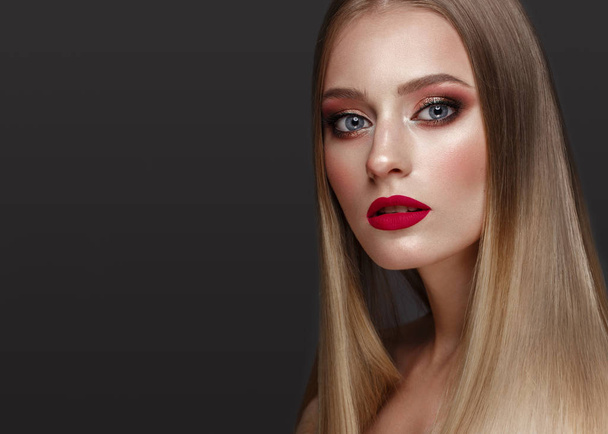 Beautiful blond girl with a perfectly smooth hair, classic make-up and red lips. Beauty face - Фото, изображение