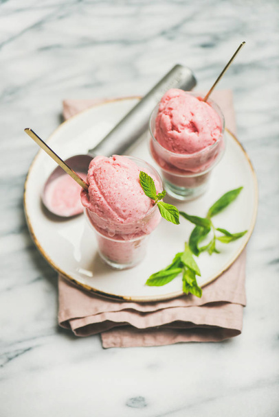 Healthy low calorie summer dessert. Homemade strawberry yogurt ice cream in glasses over light grey marble table background - Φωτογραφία, εικόνα