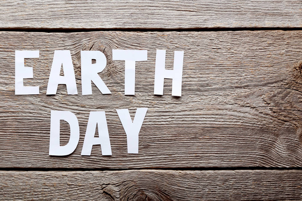 Inscription Earth Day on grey wooden table - Foto, Imagen