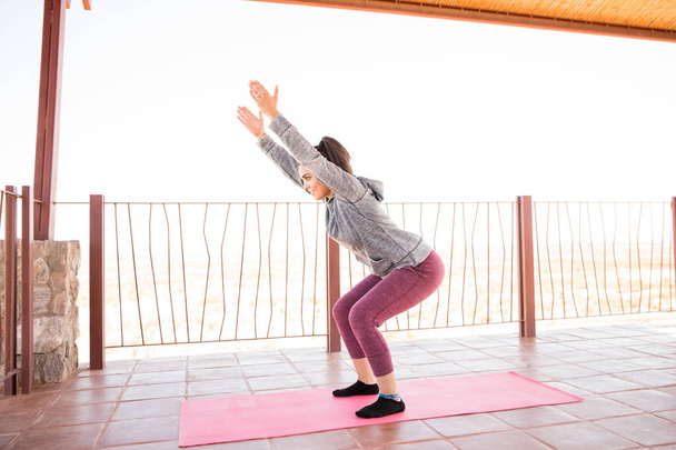 Pleine longueur de forme jeune femme hispanique pratiquant la pose de chaise yoga au studio de fitness
 - Photo, image