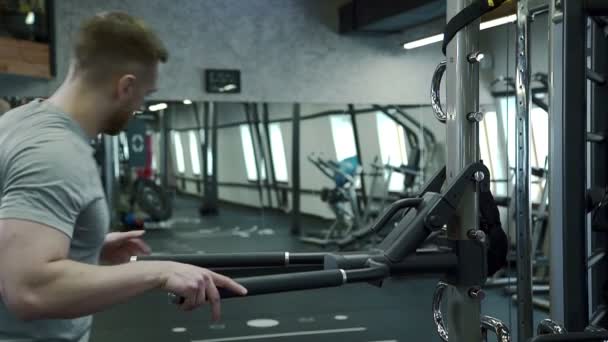 Portrait of young man, who is doing chest version of dips exercise in modern gym. - Záběry, video