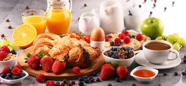 Breakfast served with coffee, juice, croissants and fruits - Photo, Image