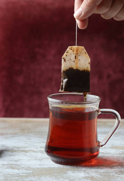Dipping tea bag into a glass - Fotografie, Obrázek