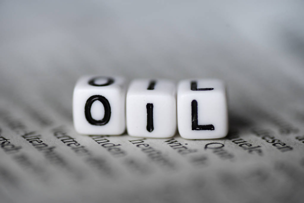 Word olie gevormd door hout alfabet blokken op krant - Foto, afbeelding
