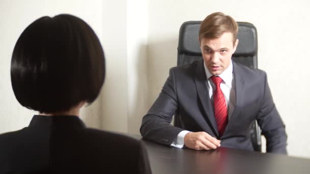 un uomo in giacca e cravatta fa domande a una donna bruna in un'intervista. 4k. intervista. reclutamento
 - Filmati, video
