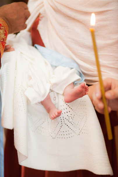 Baby feet on parents hands in church ceremony - 写真・画像