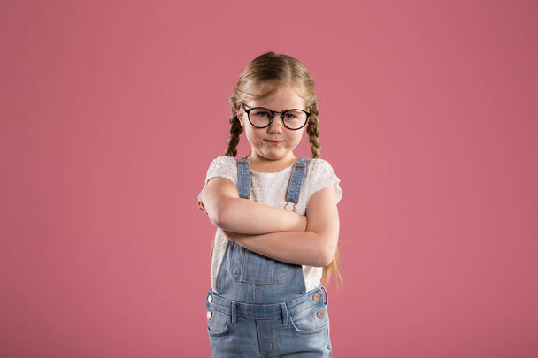 Young girl in glasses standing with folded arms - Фото, изображение