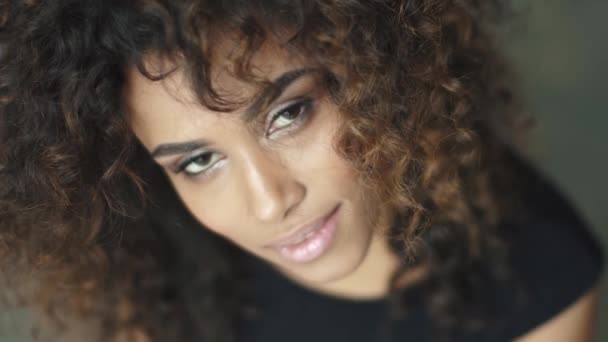 close-up portrait of a cute young woman with curly hair and a charming smile - Footage, Video