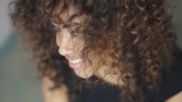 curly girl turns and looks at the camera. close-up portrait - Footage, Video