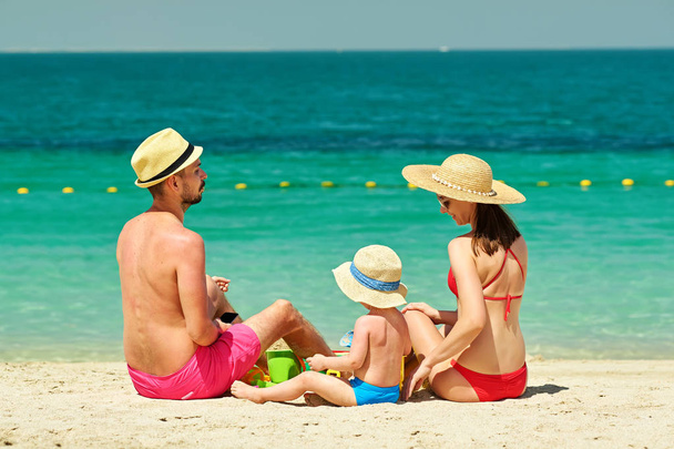 маленький хлопчик з матір'ю та батьком на пляжі. Концепція сім'ї на пляжі
.  - Фото, зображення