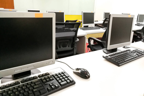 Classe d'ordinateur vide avec moniteurs sur le dessus de la table
 - Photo, image