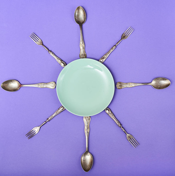 Plate with cutlery over purple background. Space for text - Photo, Image