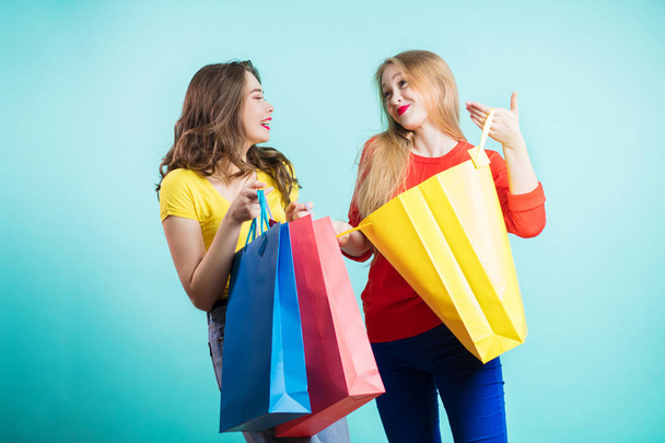 Two young joyful women with colorful shopping bags - Photo, image