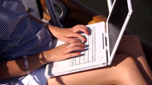 piękna blondynka z jej laptopa na pokładzie luksusowego jachtu - Materiał filmowy, wideo