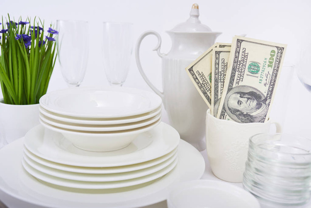 Set von neuen sauberen weißen Geschirr und Geld isoliert auf weißem Hintergrund - Foto, Bild