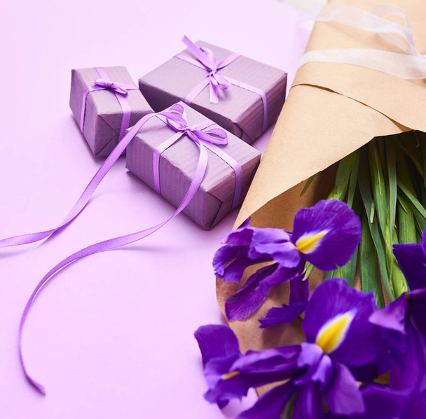Greeting card with spring purple iris flowers and tiny gift box on purple background,, space for your text. top view - Fotografie, Obrázek