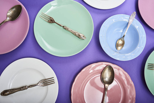 Set of different colorful dishes with cutlery over purple background - Foto, Bild