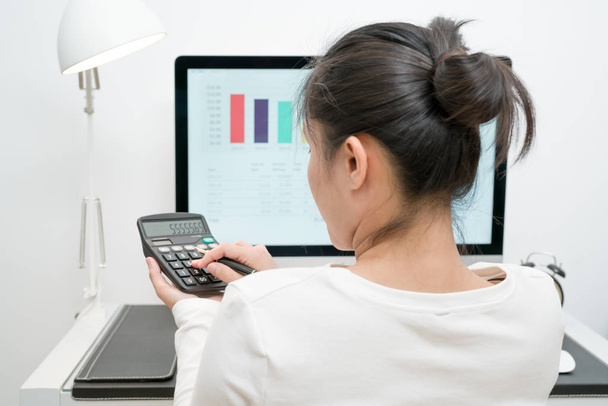 młody biznes kobiety pracują z Kalkulator i komputer stacjonarny aand pióra na nowoczesne biurko - Zdjęcie, obraz