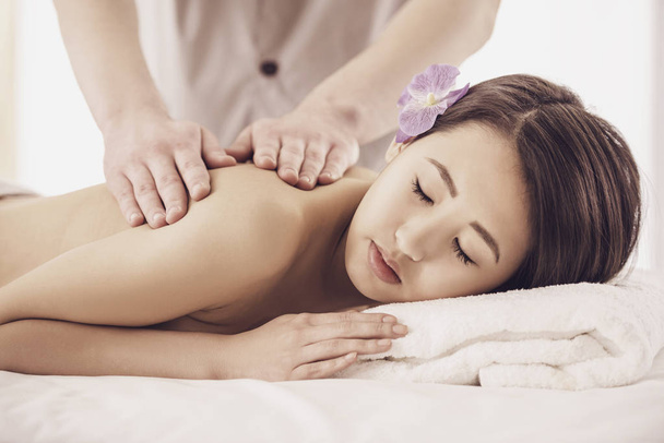 Side view. Beautiful asian woman having massage in beauty salon - Photo, Image