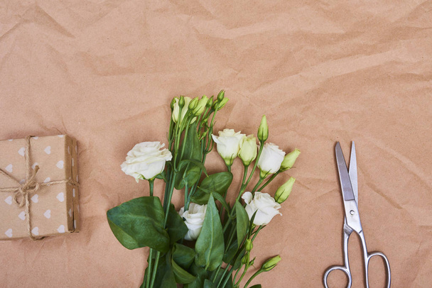 春の白のトルコギキョウの花と茶色の紙の背景、テキストのスペースにギフト ボックス グリーティング カード。トップ ビュー - 写真・画像