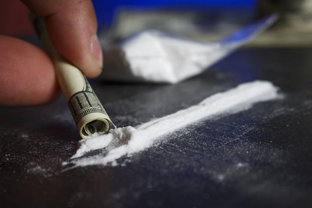 Drug addict man using narcotics, sniffing cocaine lines white po - Photo, Image