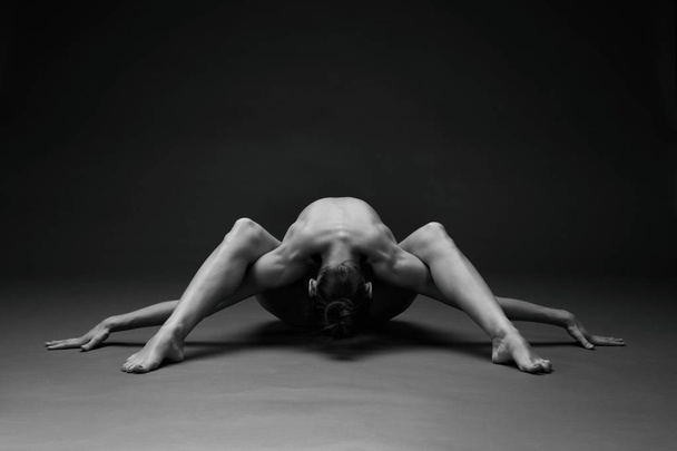Naked woman. Nude girl doing yoga. Gymnastic exercises. Female beauty of a body. - Foto, Bild