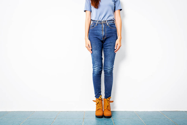 Jeune fille bleu jeans brun chaussures mur blanc
. - Photo, image