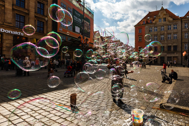 Man launches soap bubbles entertain tourists in the old city cen - Φωτογραφία, εικόνα