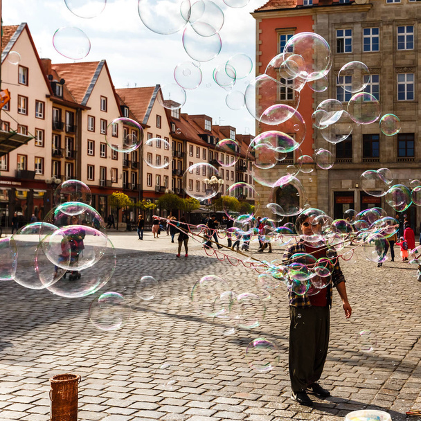 Man launches soap bubbles entertain tourists in the old city cen - Fotoğraf, Görsel