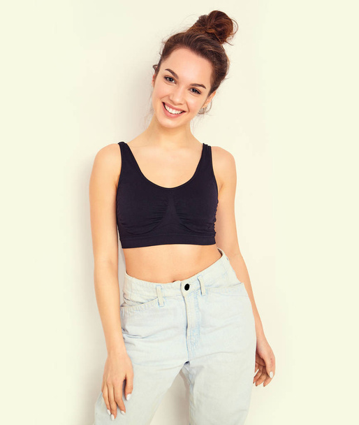 Portrait of young beautiful brunette woman girl model with nude makeup in summer T-shirt top and jeans hipster clothes posing near wall. Going crazy - Photo, Image
