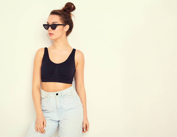 Portrait of young beautiful brunette woman girl model with nude makeup in summer T-shirt top and jeans hipster clothes posing near wall. Going crazy - Φωτογραφία, εικόνα