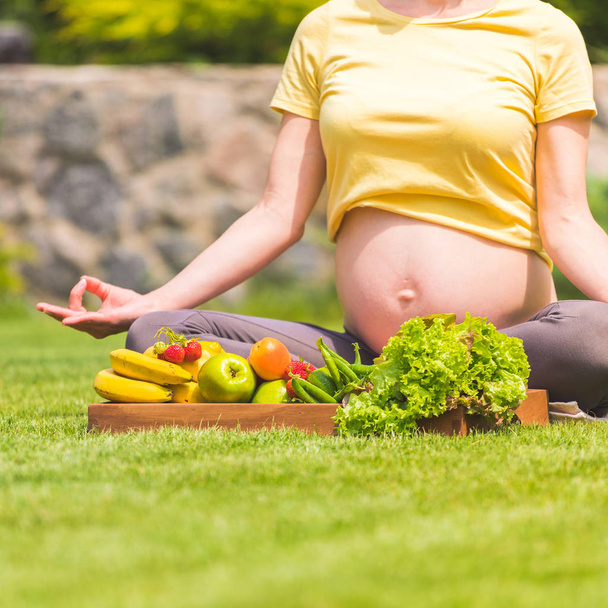 Pregnant woman practicing meditation and relaxation in nature - Foto, Imagen