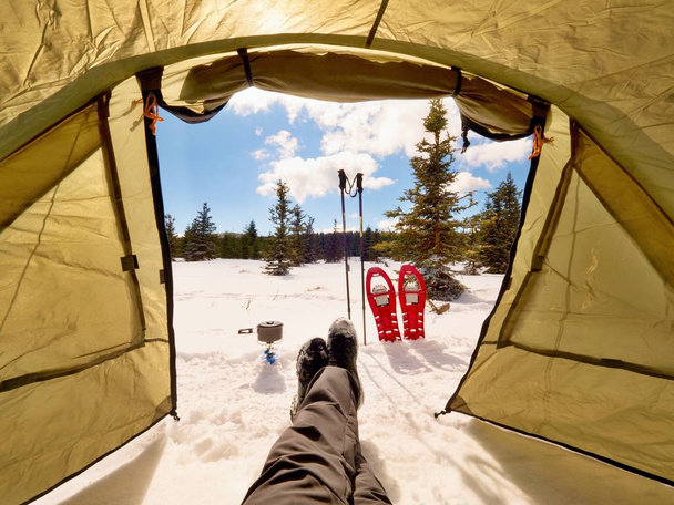Mann entspannt sich. Winterblick vom Eingang des Zeltes aus  - Foto, Bild