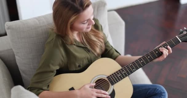 Young adult female playing acoustic guitar - Felvétel, videó
