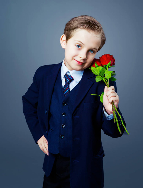 hansome boy wearing a black suit with roses in his hands  - Foto, Bild
