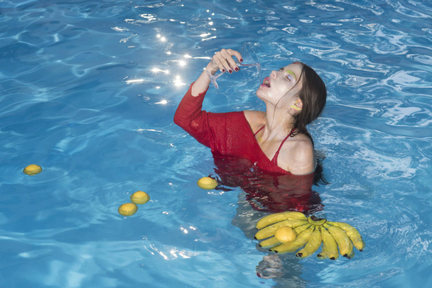 Summer vacation and travel to ocean. summer splash and fruit mix at girl swimming in pool drink from glass - Foto, afbeelding