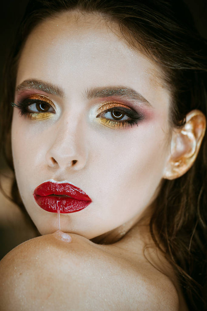 Woman run saliva from mouth with red lips, makeup. Woman with fresh skin face, skincare. Beauty model with glamour look. Fashion girl with bright makeup, beauty. Skincare, cosmetics and visage. - Photo, Image
