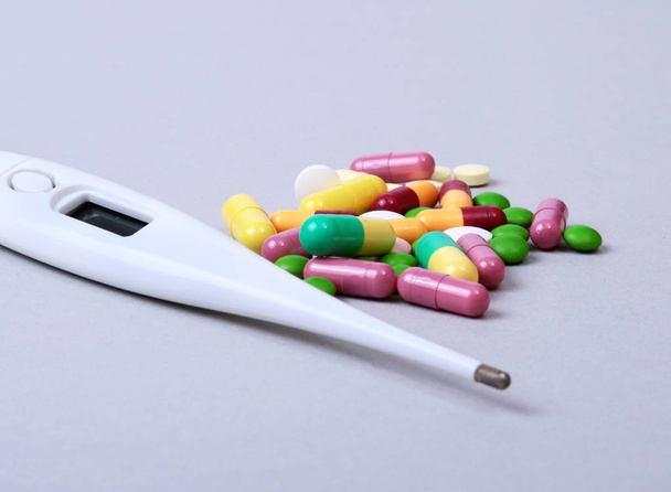 Pillen en medische thermometer op witte achtergrond. . - Foto, afbeelding