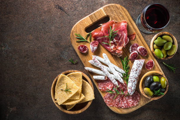 Antipasto - Scheibenfleisch, Schinken, Salami, Oliven und Wein von oben. - Foto, Bild