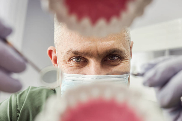 Οδοντίατρος πάνω από το στόμα του ανοιχτό ασθενή που ψάχνει στα δόντια. Στοματική φροντίδα. Vew μέσα - Φωτογραφία, εικόνα