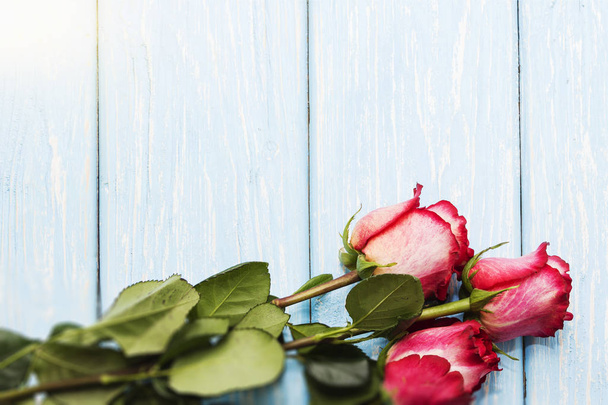 Романтический фон с красными розами на деревянном столе
. - Фото, изображение