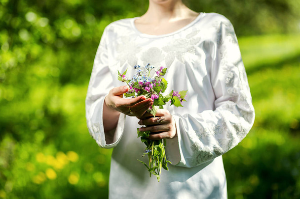 young girl holding a bouquet of wild bright colors - Фото, зображення