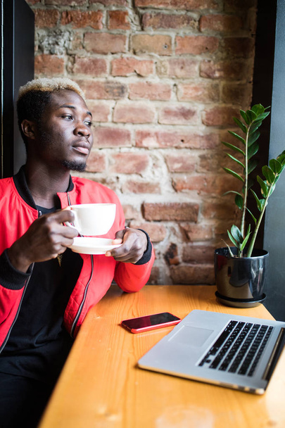 Portrait of a happy afro american man drinking morning coffee at cafe - Фото, зображення