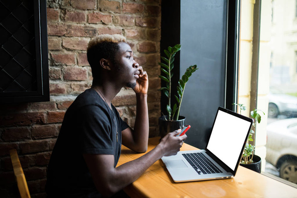 Yan portre için kopya alanı kafede beyaz ekran ile bir genç afro Amerikalı adam çalışma dizüstü - Fotoğraf, Görsel