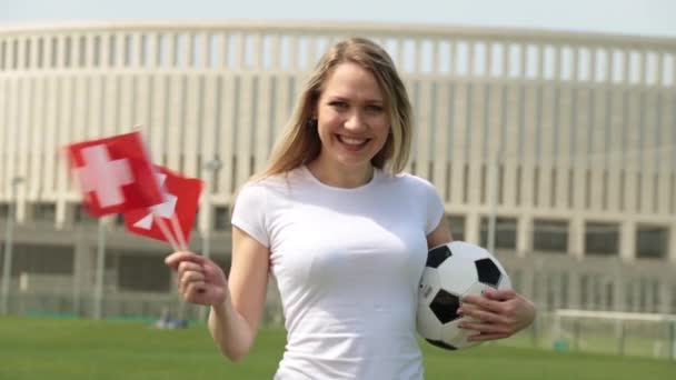 Tifoso di calcio con la bandiera della Svizzera. Donna con bandiera svizzera e pallone da calcio
. - Filmati, video