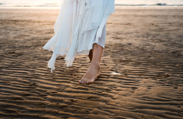 Lány séta a tengerparton, a fehér ruhában - Fotó, kép